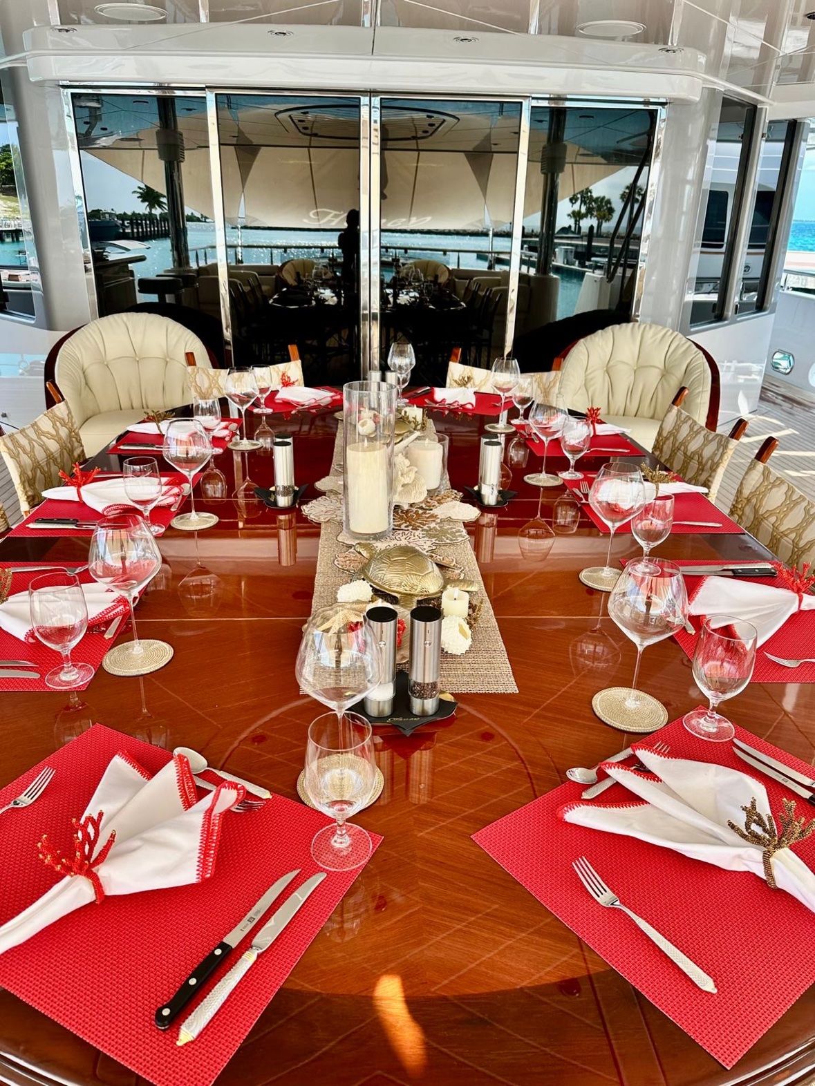 Red placemats and coral napkin rings with candles on the deck table