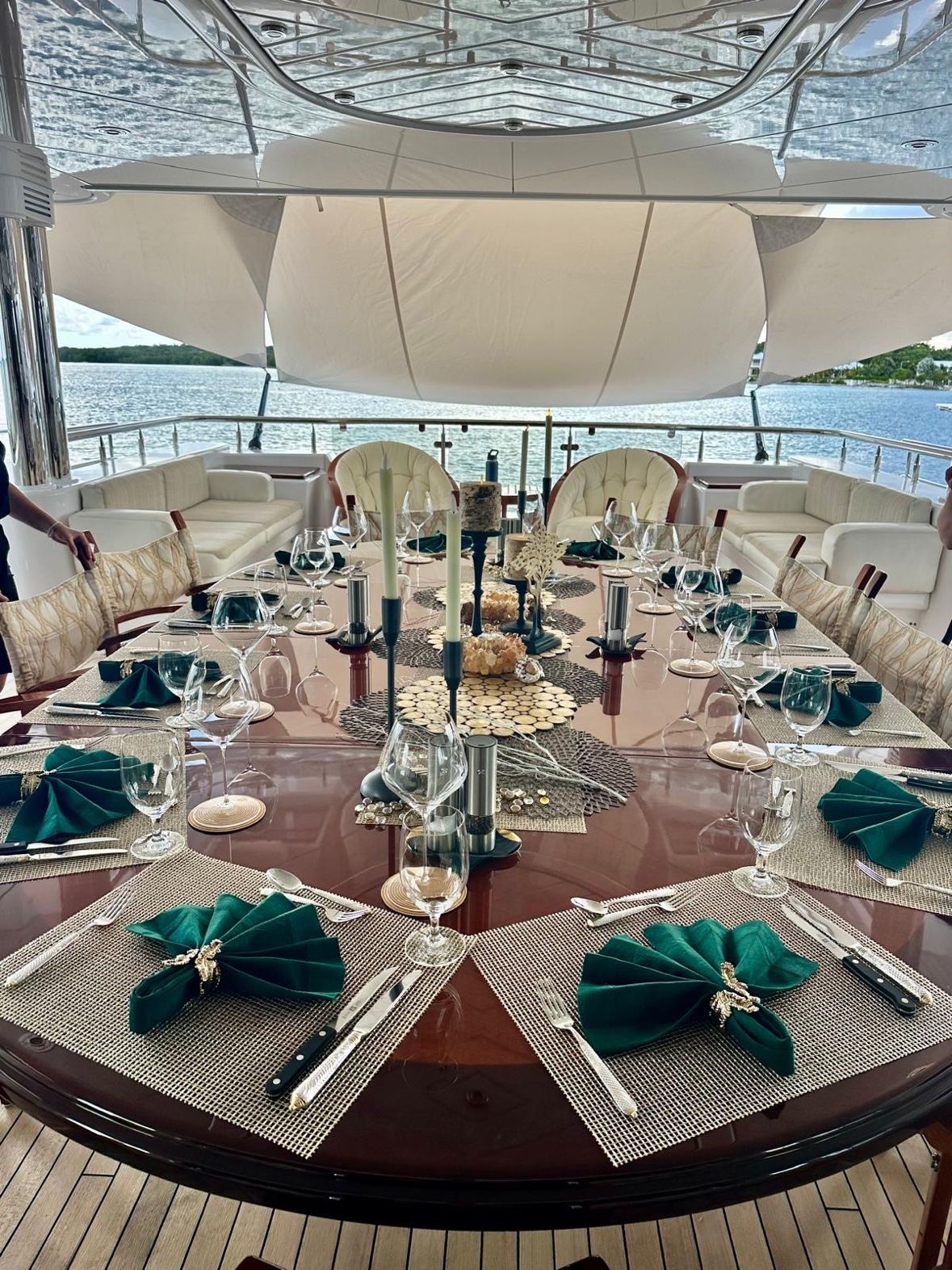 Deck dinner set with emerald napkins and candles at anchor