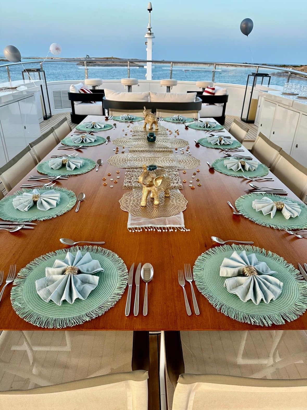 Deck table with gold elephants and mint placemats for a celebration